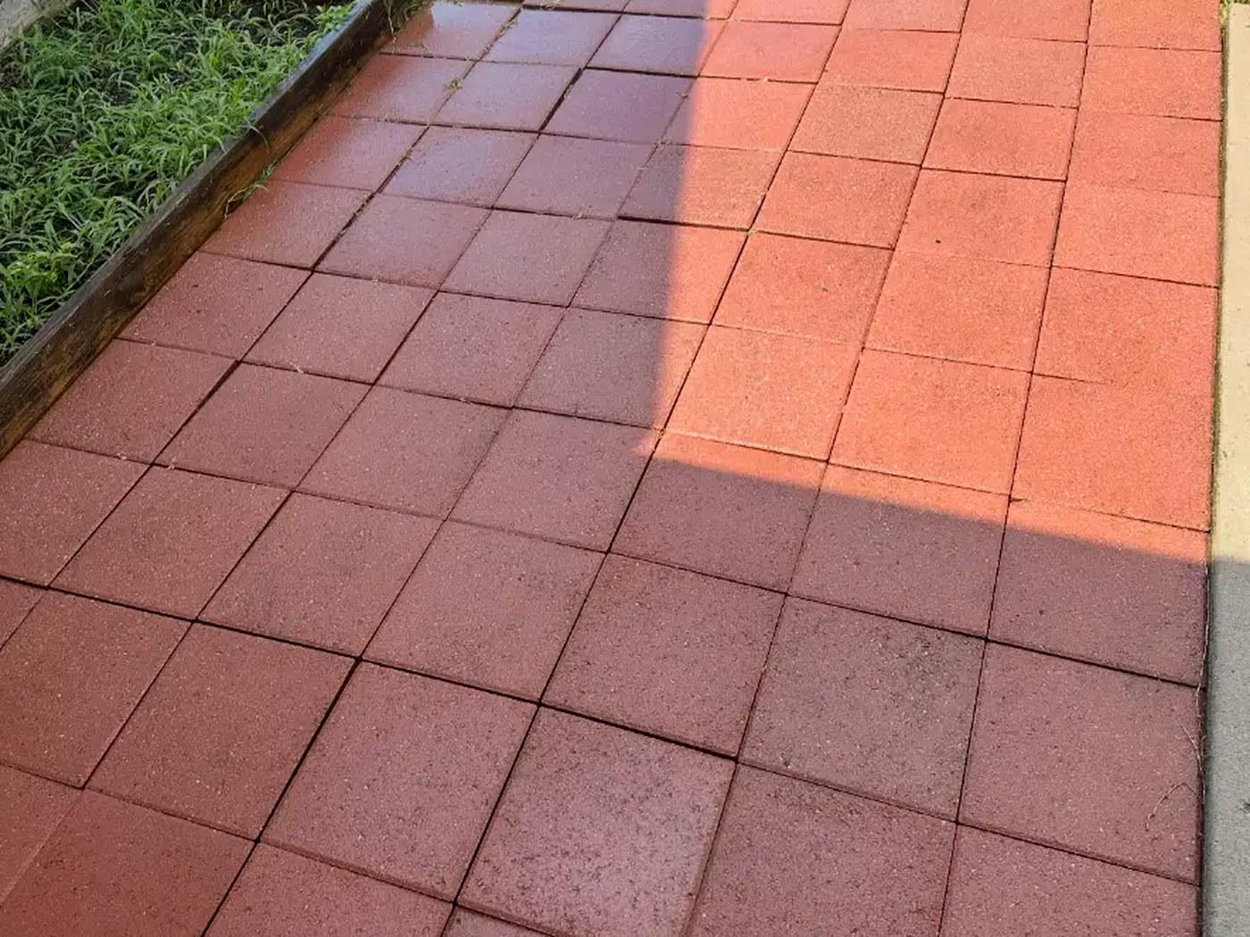 Bright, evenly cleaned red brick paver patio after pressure washing