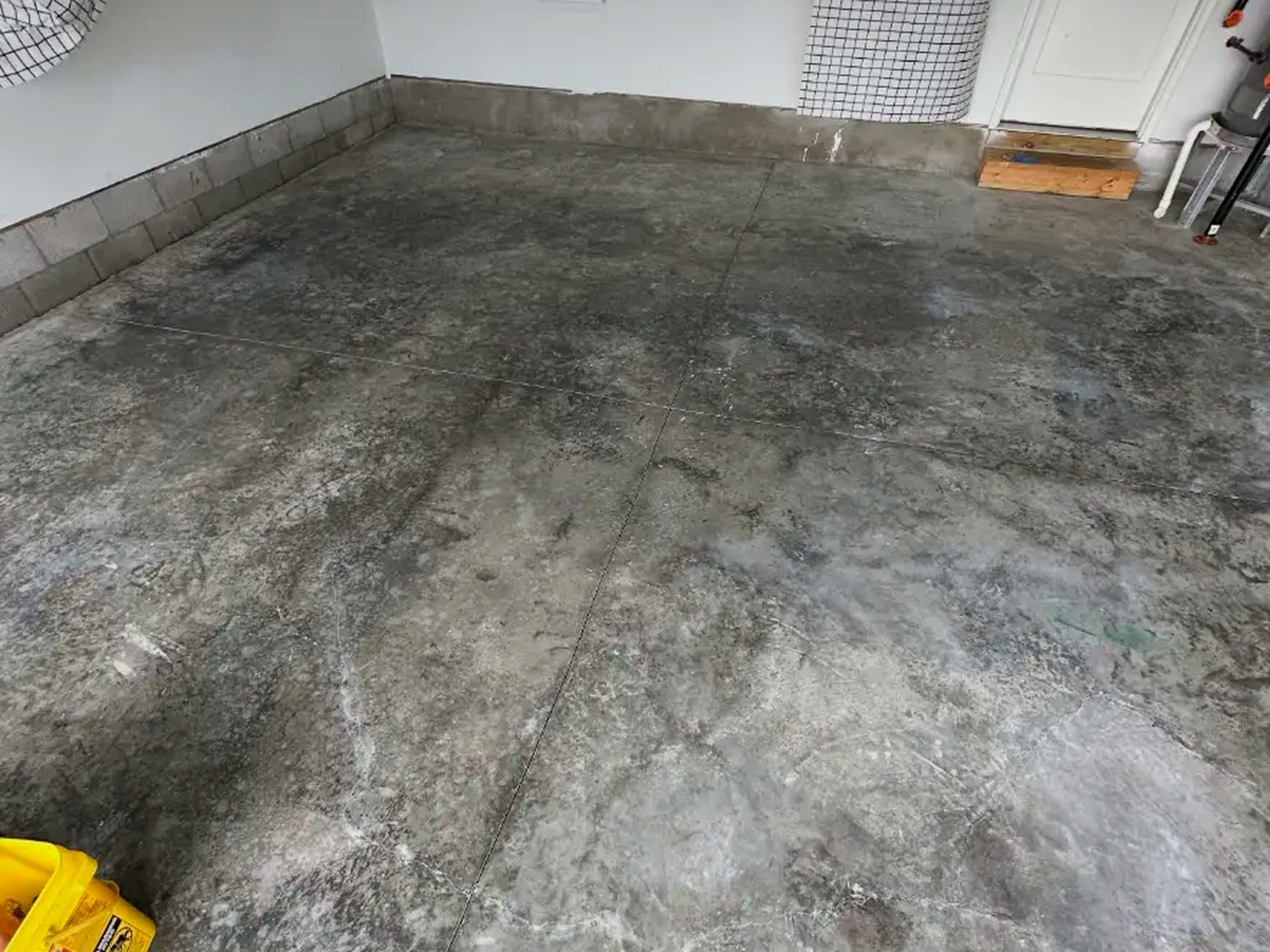 Stained bare concrete garage floor before epoxy coating