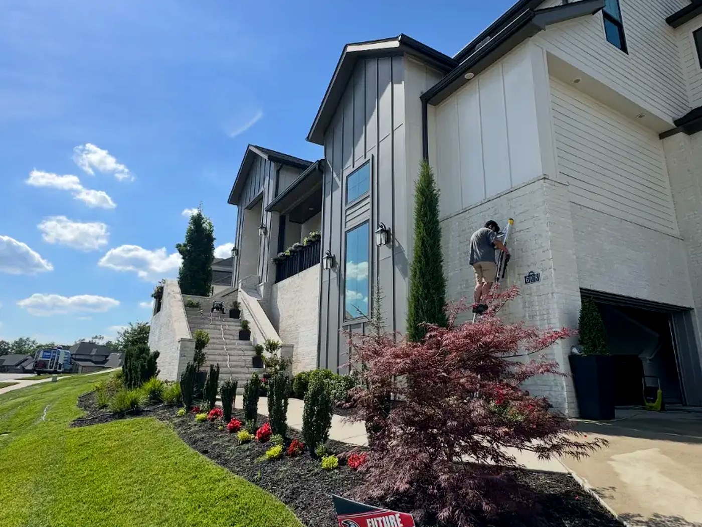 Lollie technician on a ladder washing the upper exterior of a Nashville-area home